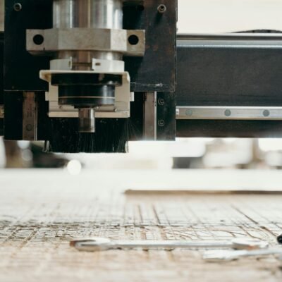 Close-up of a CNC machine carving a wooden surface indoors, showcasing precision equipment.