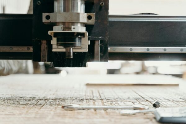 Close-up of a CNC machine carving a wooden surface indoors, showcasing precision equipment.