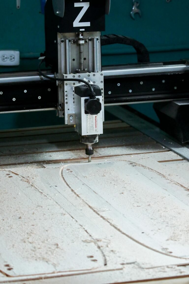 Close-up of a CNC milling machine operating in a workshop setting, cutting patterns into wood.