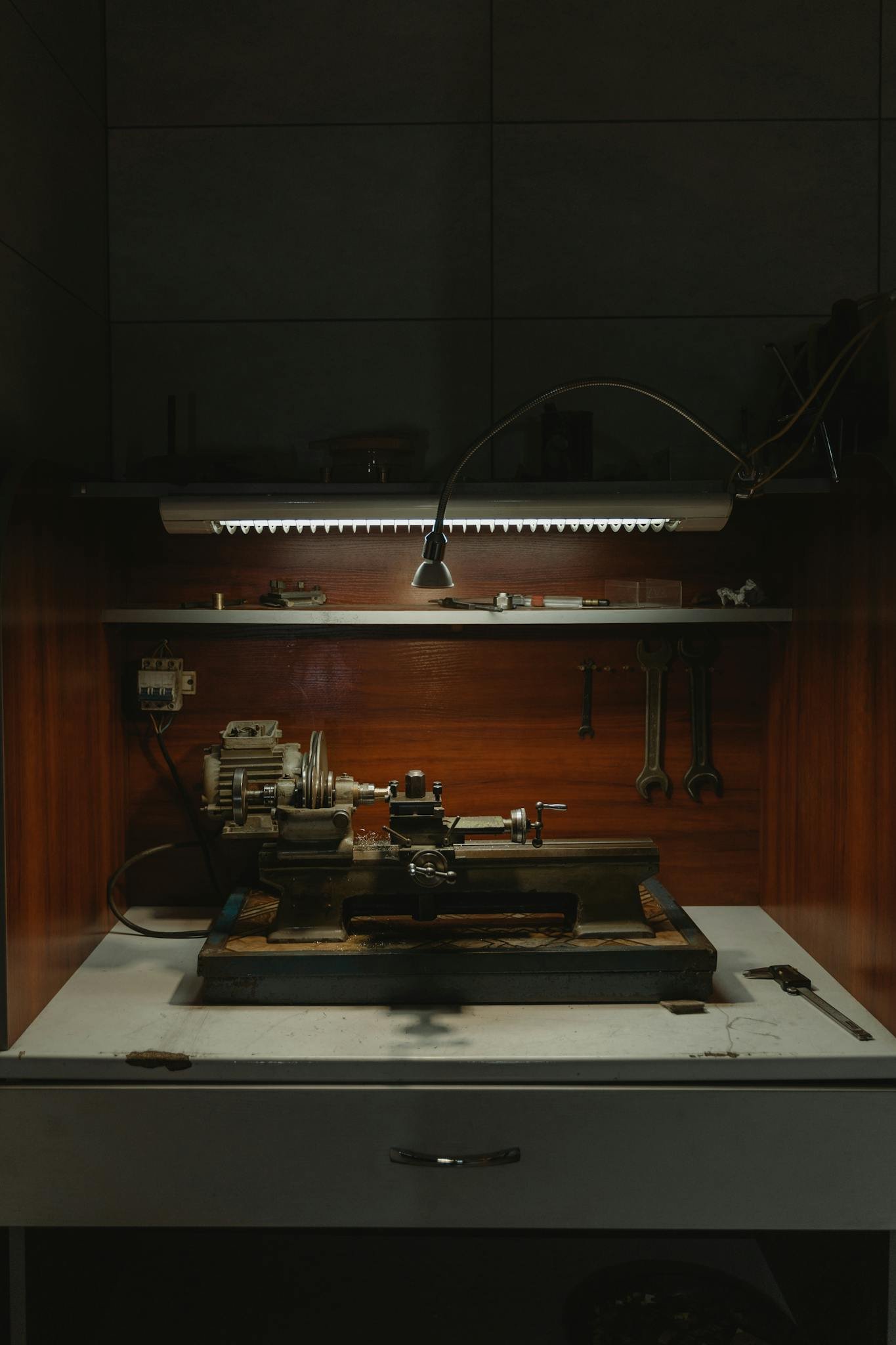 Vintage machinery set up in a dark, moody workshop space.